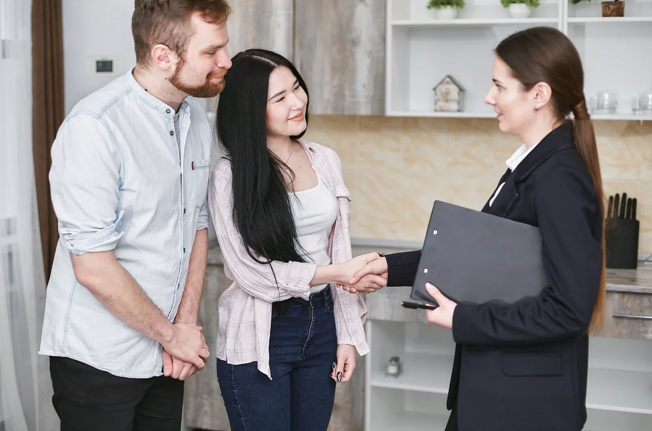 A real estate agent showing a young couple a home